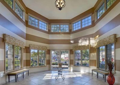 Gorgeous lobby with high ceilings and expansive windows in Village Square Apartments clubhouse
