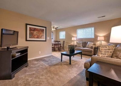 Large, carpeted living area with open concept leading into dining room