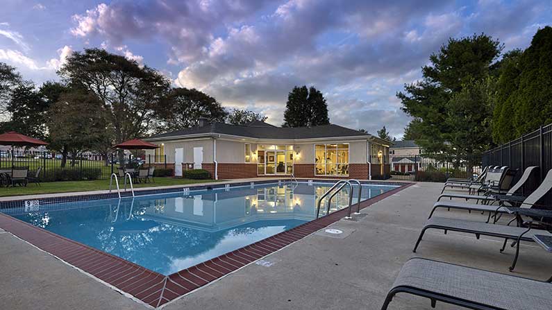 Pool with lounge chairs at Village Square Harleysville, PA apartments.