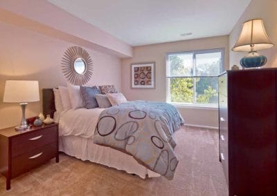 Spacious bedroom with carpeting and large window bringing in lots of natural light