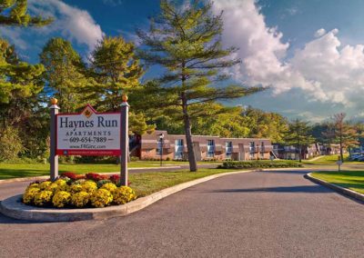 Entrance to Haynes Run Apartments with sign and well-kept landscaping