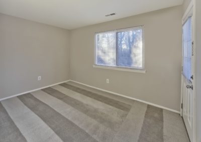 Carpeted room with large window and exterior door