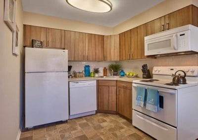 Spacious kitchen with white appliances, tiled floor, and wood cabinets