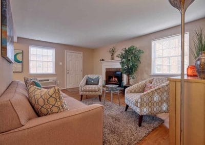 Spacious living room with large windows and a brick fireplace