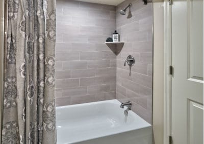 Contemporary shower with grey tiles and stainless steel hardware
