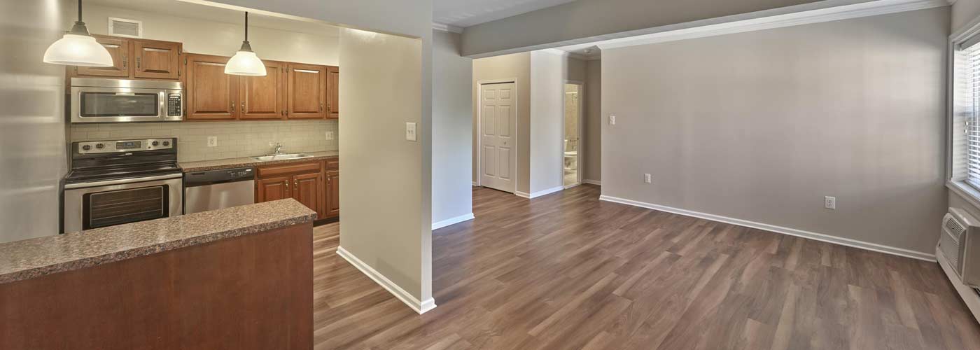 Spacious living area with hardwood style floors and breakfast bar at Chestnut House Apartments