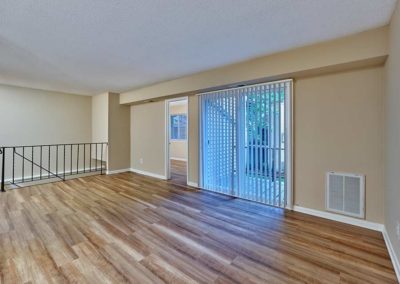 Spacious living area with hardwood floors and sliding glass doors out to patio