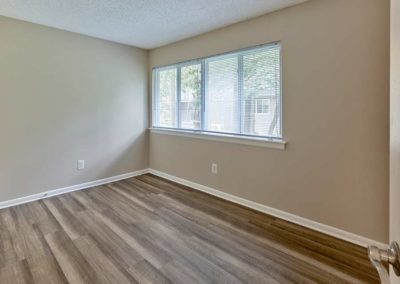 Moderate sized bedroom with hardwood flooring and lots of natural light