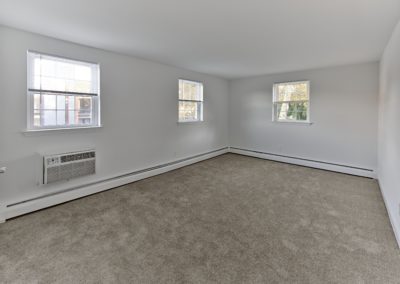 Spacious living area with plush carpeting and multiple windows at an apartment for rent in Wayne, PA