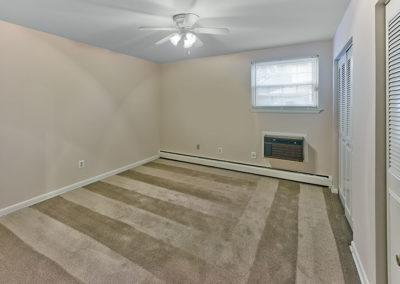 Carpeted bedroom with in wall air conditioning unit at Haddon Heights, NJ apartments