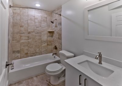 Bathroom with tiled bathtub and recessed light fixture at Brookdale Apartments