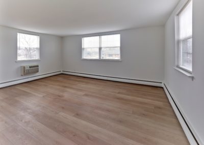 Spacious living room with natural lighting and hardwood-style floors at Brookdale Apartments