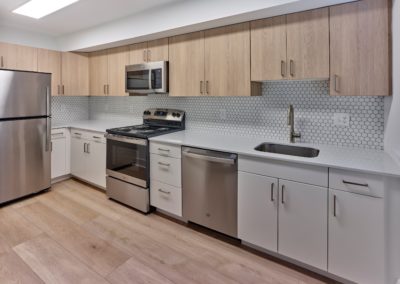 Spacious kitchen with custom tile backsplash and stainless steel appliances