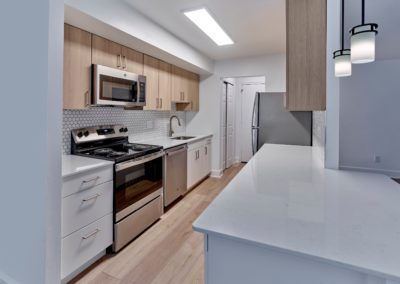 Kitchen with stainless steel appliances and designer tile backsplash at Brookdale Apartments